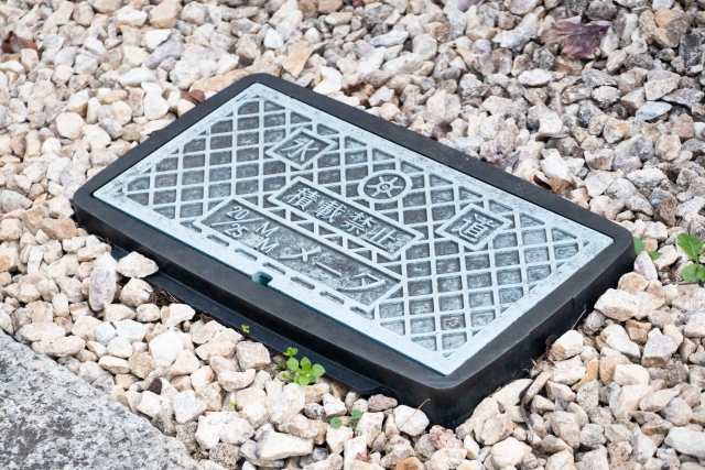 戸建ての水道元栓の場所。敷地内の地面に埋まったメーターボックス（量水器）の蓋を開けると、中に水道メーターと元栓がある。青い樹脂製や鉄製の蓋が目印